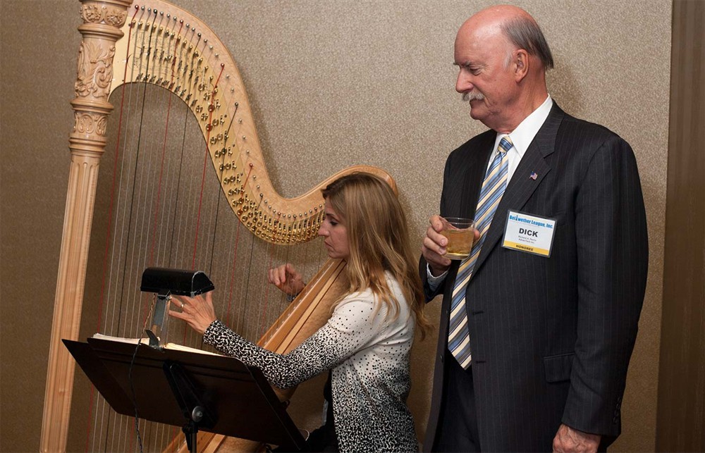Bellwether Class of 2014 Honoree Richard Perrin (left) admires the musical stylings of harpist Laura Utley.