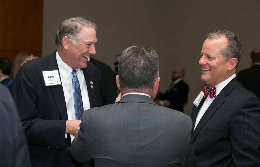 The Wetrich Group’s Carl Meyer (left) laughs with Beaumont Health’s Ed Hardin (right) and SMI’s Dennis Orthman (center, back to camera).