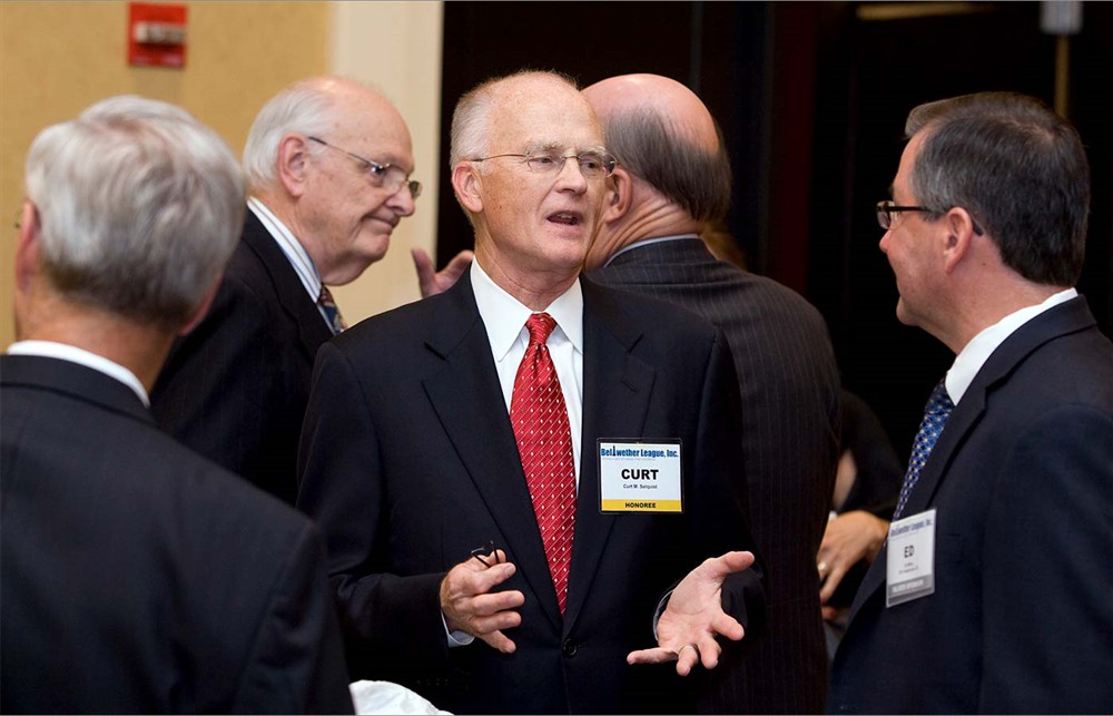 Bellwether Class of 2010 Honoree Curt Selquist (center) speaks with GS1 Healthcare US’ Ed Miles (right) with GS1 Healthcare US’ Dennis Harrison in the foreground (far left) and Bellwether Class of 2010 Honoree Dan Mayworm in the background (left of Selquist), along with Bellwether League’s Dick Perrin (immediately behind Selquist).