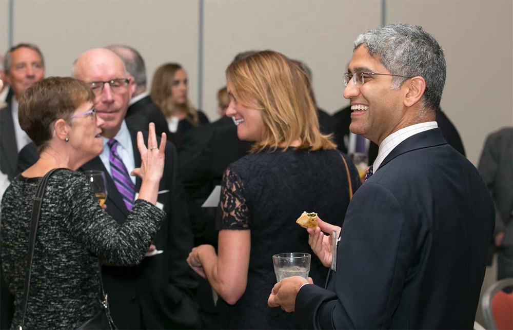 New York-Presbyterian’s Anand Joshi, M.D., (right) as Nancy LeMaster (Bellwether Class of 2015) gestures in the background conversation (far left) with Vizient’s Mike McMahon and Molly Matthews (back to camera).