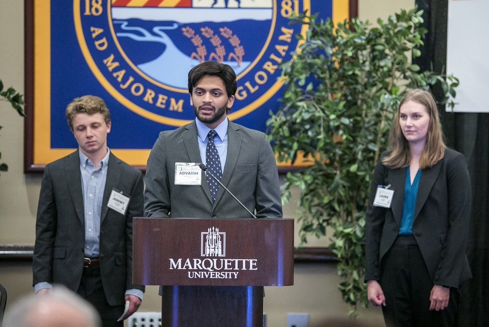 Flanked by fellow Michigan students Jeremy Segal (left) and Laura Ely (right), Advaidh Venkat introduces their capstone project.