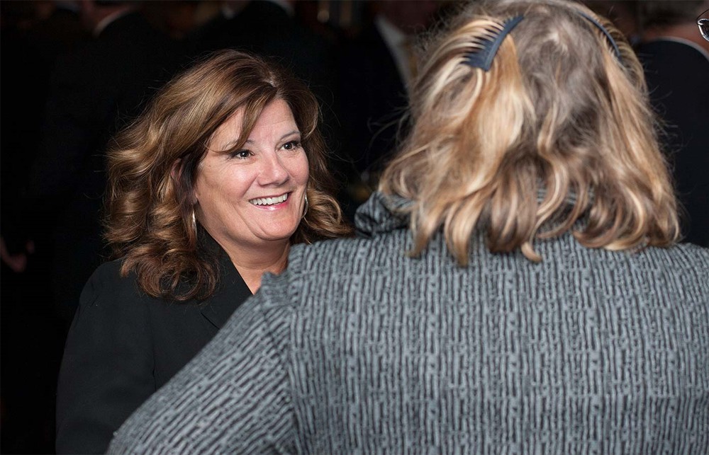 ROi’s JoAnne Levy (back to camera) shares a thought with ROi’s Scott Nelson (left), Gene Kirtser (center), and Founding/Platinum Sponsor Premier’s Rick Salzer (right).