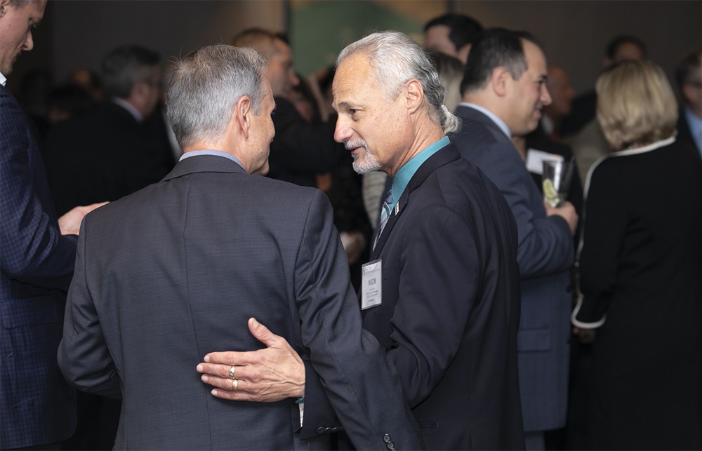 Bellwether League Chairman Nick Gaich (Bellwether Class of 2013) embraces NCI Consulting’s Jim Dausch (left, back to camera).