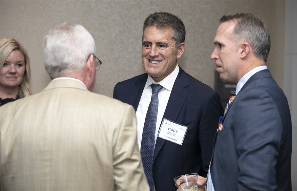 Owens & Minor’s Cody Phipps (center) (Founding Sustaining Sponsor) with Owens & Minor’s Joe Zaluzney (right) and Brent Johnson (Bellwether Class of 2014) (center, back to camera) and Lindsay Leaders (far left).